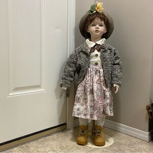 Vintage Collectible Porcelain Charming Doll with Gray Jacket and Floral Skirt